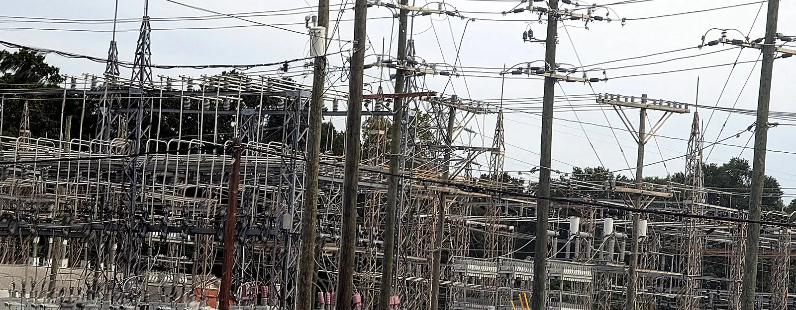 Electrical substation with steel switchgear structures and utility poles